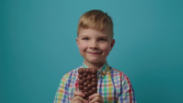 Le mamme portano via la barretta di cioccolato formano le mani dei bambini e danno al figlio un'insalata alimentare sana. Il ragazzo non vuole mangiare verdure. Bambino scontento che tiene il cavolo in mano. — Video Stock