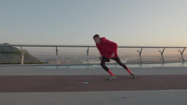 Aktiv 20 'er mand gør morgen kører øvelser på solopgang. En sund, sporty livsstil. Håndholdt skud. – Stock-video