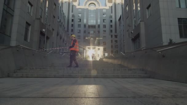 Man running though red and white warning tape stretched by worker across building. Healthy lifestyle everywhere. Running on the street in the morning. — Stock Video