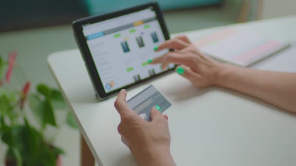 Kadın eli banka kartını tutuyor ve tablet bilgisayardan online alışveriş yapıyor. İnternet dükkanından aletler seçen ve banka kartıyla alışveriş yapan kadın. — Stok video