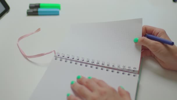 Vrouwelijke hand opschrijven Home Budget teken in notebook. Vrouw die schrijft met een pen aan tafel. — Stockvideo