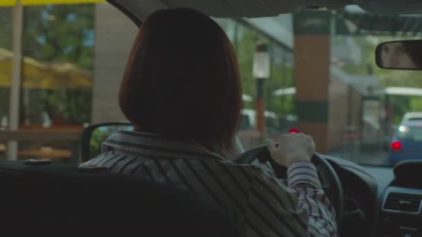 Una donna che guida l'auto al ristorante fast food. Coda auto per l'ordinazione di cibo e portare via. — Video Stock