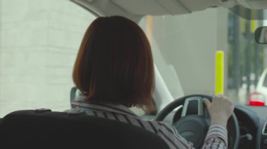 Faturayı cep telefonuyla ödeyen bir kadın ve arabada oturan bir terminalle irtibat kuramayan bir kadın. Şoför, fast food restoranında cep telefonuna NFC ödemesi yapmış..