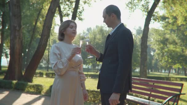 Gerade hat ein Ehepaar im Park Sekt getrunken. Junge Familie feiert gemeinsam Hochzeit. Mann und Frau küssen sich. Steadicam-Aufnahme. — Stockvideo