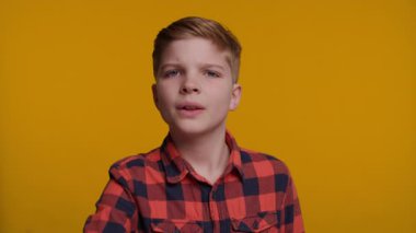 Genç bir çocuk avuç içi kameraya dönük bir şekilde elini kaldırır ve 