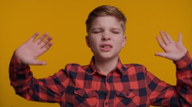 Genç bir çocuk elleriyle kulaklarını kapatırken 