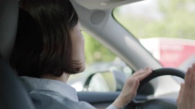 Bir kadın şarkı söyleyerek ve dans ederek araba sürerken eğlenirken kaygısız neşesini ve enerjisini ifade eder..