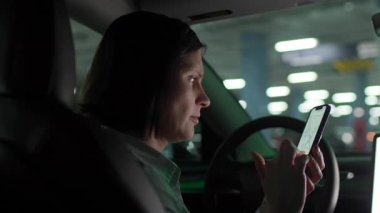 30 'lu yaşlarda bir kadın park halindeki bir arabada otururken Smartphone Navigation App kullanıyor. 4K