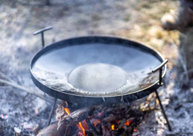 cooking in the forest park on the campfire in the pot with smoke