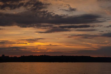 Nehir kıyısında gün batımı çarpıcı renklerle