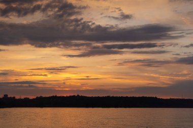 Nehir kıyısında gün batımı çarpıcı renklerle