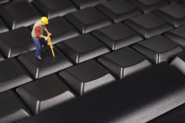 Minyatür inşaat işçisi bir siyah bilgisayar klavye üstüne