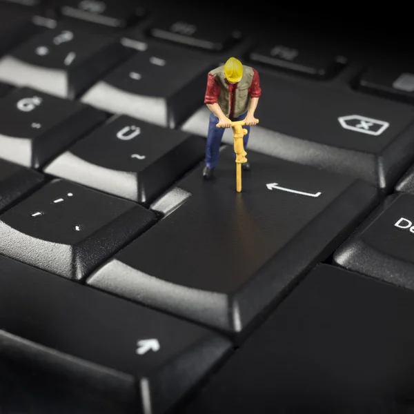 Trabajador en miniatura en la parte superior del teclado del ordenador negro — Foto de Stock