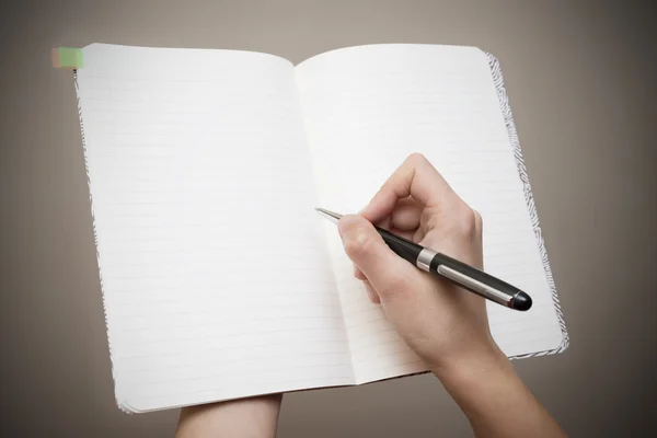 Mulher tomando notas em um caderno aberto — Fotografia de Stock