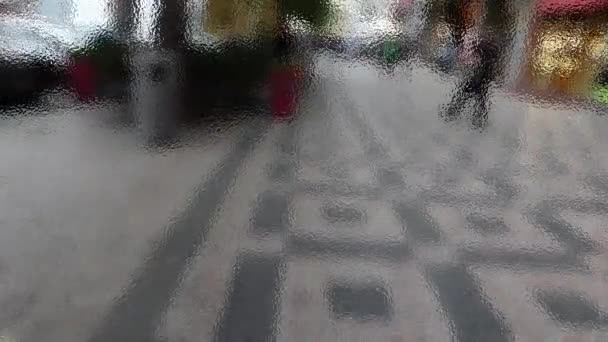 Pessoas andando na rua além de vidro fosco — Vídeo de Stock
