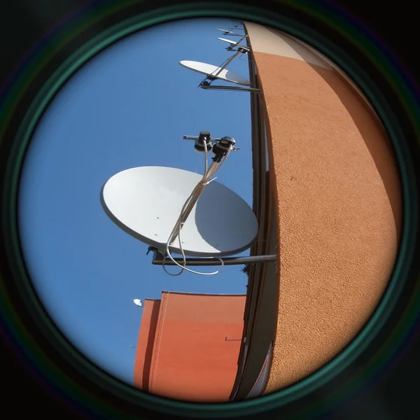 Prefab wall with satellites in objective lens — Stock Photo, Image