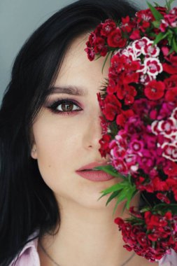 Parlak makyajlı ve çiçekli güzel esmer manken.