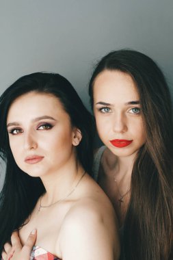 Parlak makyajlı, uzun saçlı güzel esmer kızlar. Moda ve güzellik, kozmetik kullanarak. Göz farı ve rujun canlı renkleri. Salon, makyaj sanatçısı, beyaz model..