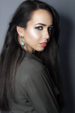 Güzel, genç bir model, parlak makyajlı, uzun saçlı bir kız. Moda ve güzellik, kozmetik kullanarak. Göz farı ve rujun canlı renkleri. Salon, makyaj sanatçısı, kırmızı dudaklı beyaz model..