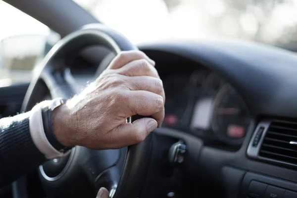Närbild på mannen händerna rör sig ratt, kör bil. — Stockfoto