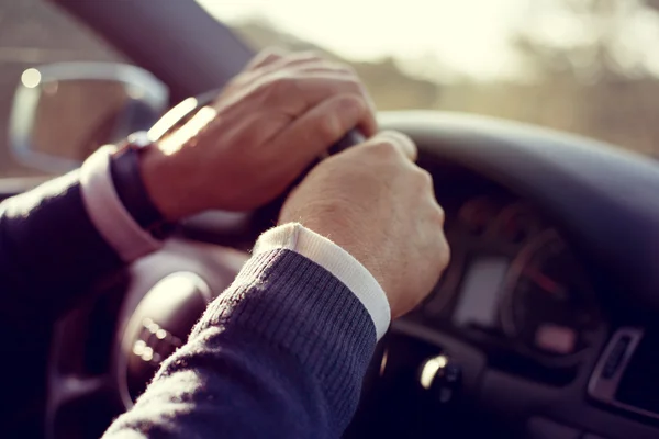 Ο άνθρωπος τα χέρια κρατώντας το τιμόνι σε κίνηση, ενώ μονάδες. Εκλεκτής ποιότητας ήχο. — Φωτογραφία Αρχείου