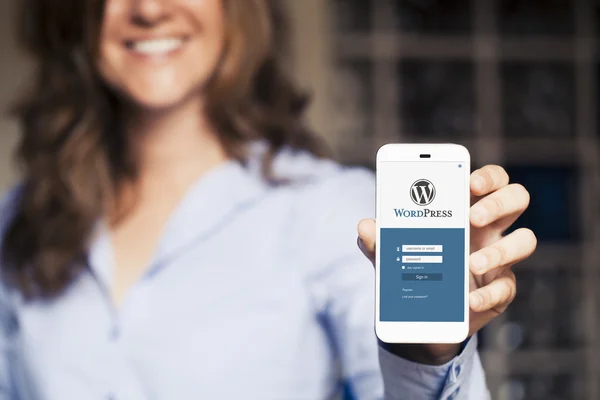 WordPress giriş Web sayfası bir cep telefonu ekran. Onu tutan kadın.