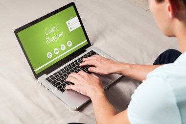 Alışveriş satırındaki bir dizüstü bilgisayar vasıl ev ile bir dizüstü bilgisayar kullanan adam.