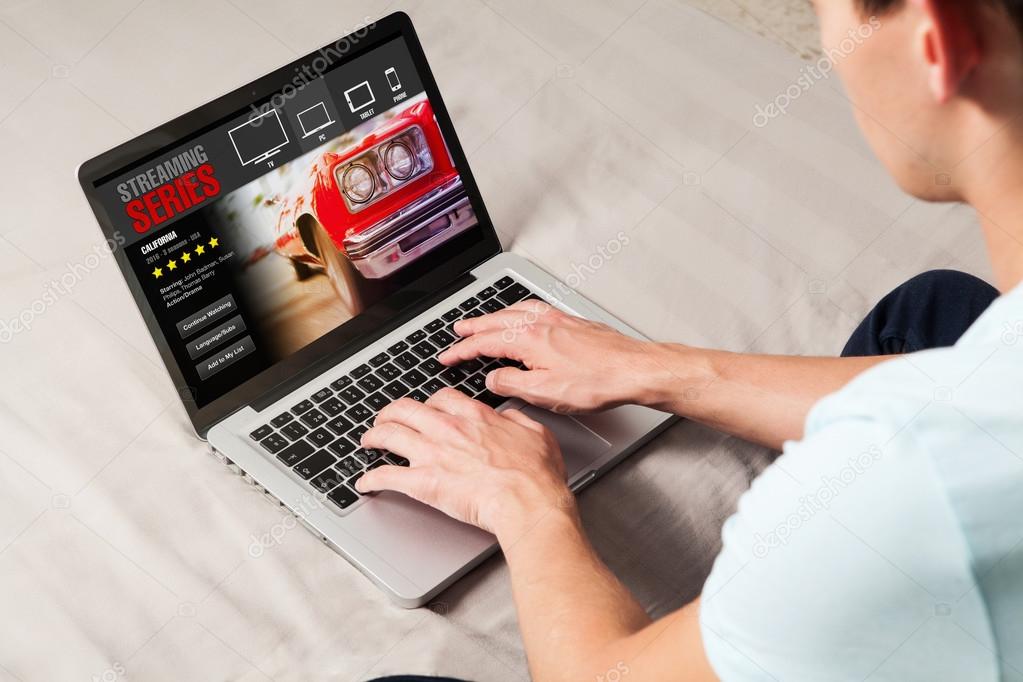 Man watching streaming series in a laptop computer at home.