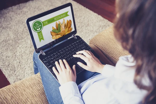 Mujer visitando un restaurante vegano sitio web sentado en casa . — Foto de Stock