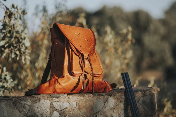 Ledertasche in einer Steinmauer auf dem Land. Jagdkonzept. — Stockfoto