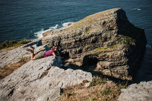 Femeia Mincinoasă Stâncă Linia Coastă Ochelari Soare Tricou Violet Marea — Fotografie, imagine de stoc