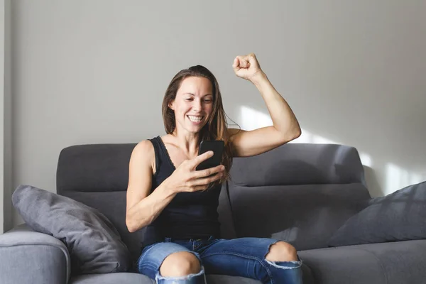 Mujer Blanca Sentada Sofá Reacciona Alegre Emocionada Levantando Brazo Como Imágenes De Stock Sin Royalties Gratis