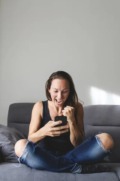 Mujer Blanca Sentada Sofá Reacciona Feliz Emocionado Notificación Móvil Imagen De Stock