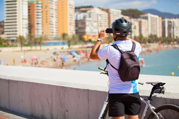 Ciclista tomando una foto de la playa — Foto de Stock