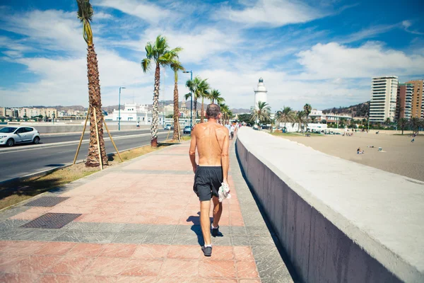 Ανώτερος άνθρωπος περπατώντας στον παραλιακό δρόμο στην ακτή — Φωτογραφία Αρχείου