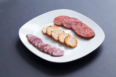İspanyol chorizo tapa siyah tablo üzerinde.