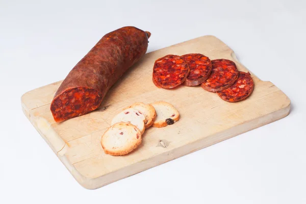 Chorizo español en rodajas sobre tabla de madera . — Foto de Stock