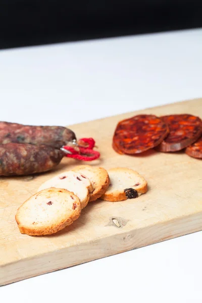 Spaanse chorizo segmenten over houten bord. Close-up. — Stockfoto