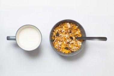 Bir fincan süt ve granola kase. Beyaz arka plan.