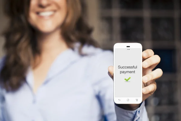 Mujer sonriente sosteniendo su teléfono móvil . —  Fotos de Stock