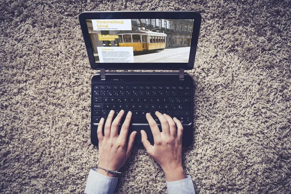 Woman hands typing on a laptop. Traveling blog on the screen. — Stock Photo, Image