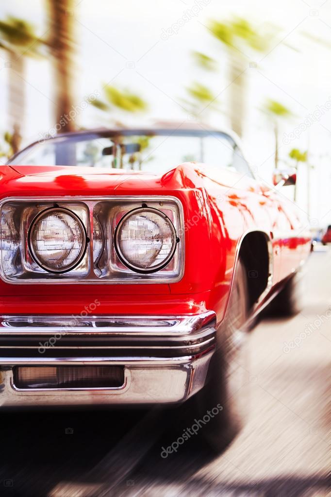 Red classic car driving fast.