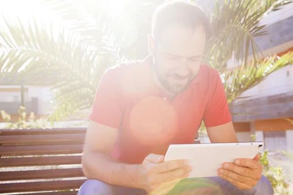 Bir bankta oturan tablet kullanan adam. — Stok fotoğraf