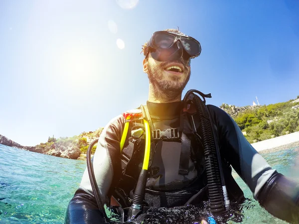 Retrato de buzo sonriente en la orilla del mar. Gafas de buceo en . — Foto de Stock