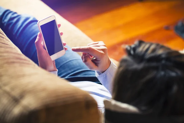 Mujer tocando la pantalla móvil con el dedo, acostada en casa. Pantalla negra . — Foto de Stock