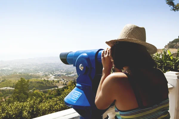 Donna che guarda il paesaggio attraverso un telescopio. tono vintage . — Foto Stock