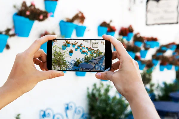 Manos femeninas tomando una foto con teléfono móvil en un pueblo blanco de Andalucía . —  Fotos de Stock