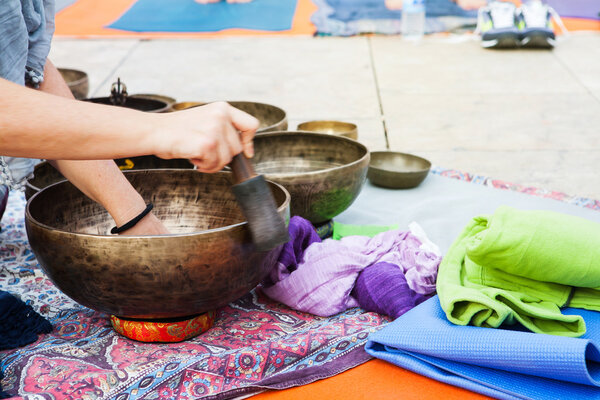 Hand playing yoga bowls outdoors.