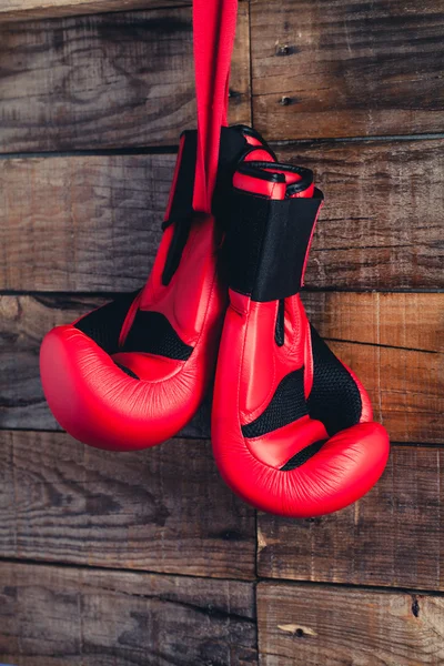 Pair of boxing gloves hanging in a rustic wooden wall. Vintage tone. — Stock Photo, Image
