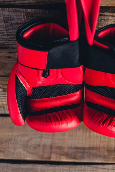 Makrodetail roter Boxhandschuhe. hölzerner Hintergrund. — Stockfoto